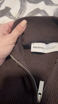 Hnědá žebrovaná bunda na zip s vysokým límcem. Má stříbrný zip a uvnitř štítek s nápisem "BERSHKA".