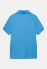 Světle modrá polo tričko s límečkem, krátkými rukávy a hladkou strukturou. Má jednoduchý design bez vzorů nebo akcentů.