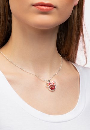 Collier en argent avec un design de nœud à pois rouges et blancs, comportant un charm circulaire avec des détails rouges et une finition brillante.