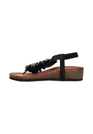 Sandalo nero realizzato in materiale sintetico con accenti a punte, cinturino regolabile, soletta in sughero e suola in gomma testurizzata per una buona aderenza.