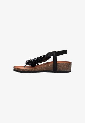 Sandalo nero realizzato in materiale sintetico con accenti a punte, cinturino regolabile, soletta in sughero e suola in gomma testurizzata per una buona aderenza.