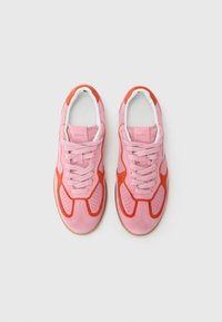 Sapatilhas de camurça cor-de-rosa com detalhes em laranja, apresentando um design perfurado, atacadores brancos e uma sola de borracha. Marca ALOHAS na língua.