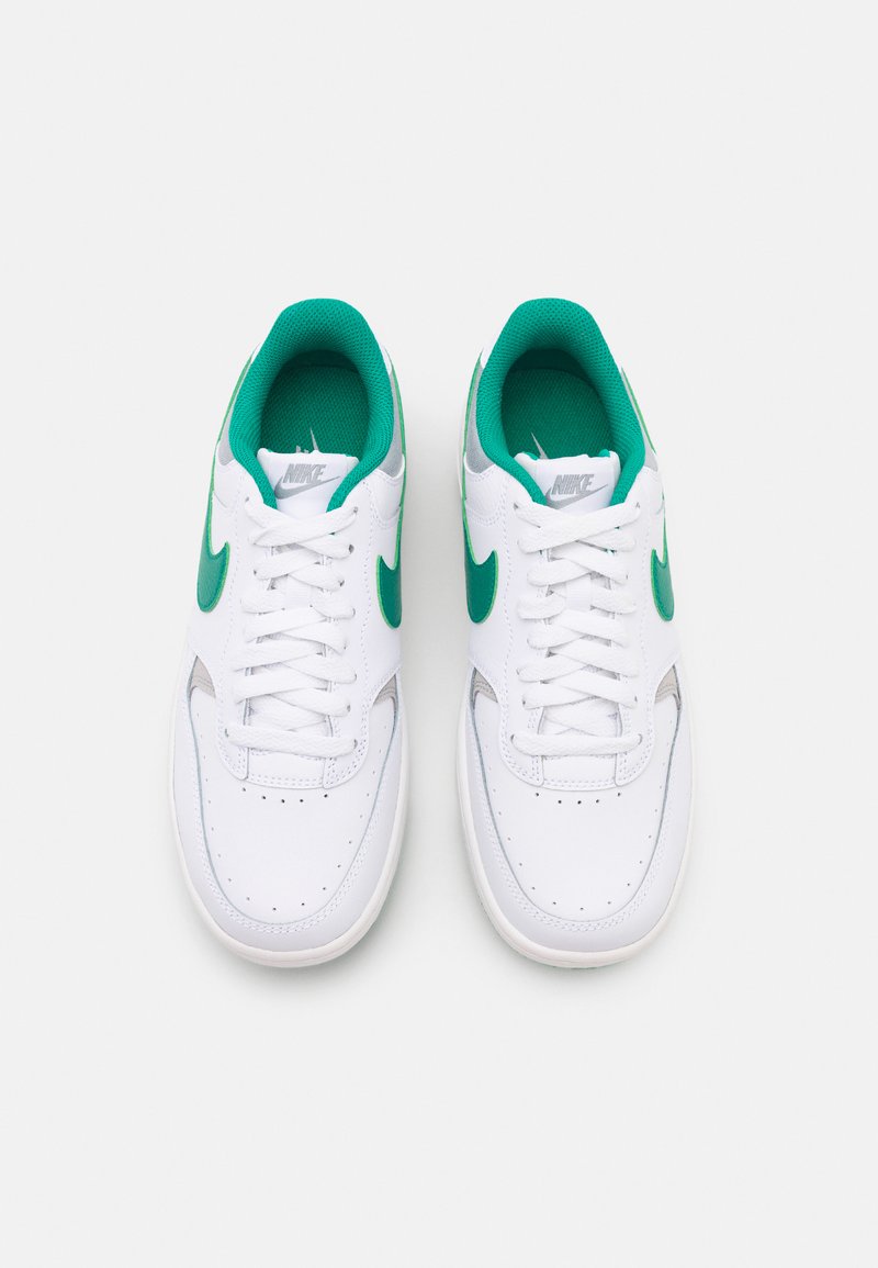 Baskets blanches avec des accents verts, dotées d'une tige en cuir lisse, d'un bout arrondi, d'une languette en mesh et d'un système de laçage.