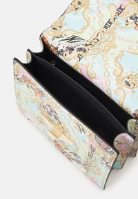 Bolso multicolor con un acabado brillante, con intrincados patrones en dorado y estampados de animales. El interior es de tela negra con una sección con cremallera.