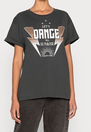 Osoba nosząca czarną koszulkę z podwiniętymi rękawami z napisem "LET'S DANCE TILL SUNRISE" i grafiką błyskawic na przodzie.