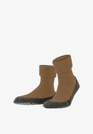 Chaussettes en laine marron avec un revers texturé et des semelles en feutre gris foncé, ornées de petits pois blancs le long du bord.