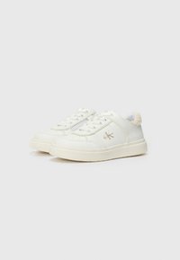 Baskets en cuir blanc avec des accents cousus, bout rond, semelle en caoutchouc texturé et garniture en fausse fourrure à l'arrière. Détail discret du logo sur le côté.