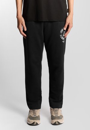 Schwarze Sweatpants mit bequemer Passform, ausgestattet mit einem weißen grafischen Logo am linken Oberschenkel. Weicher Stoff mit glatter Textur und elastischem Bund.