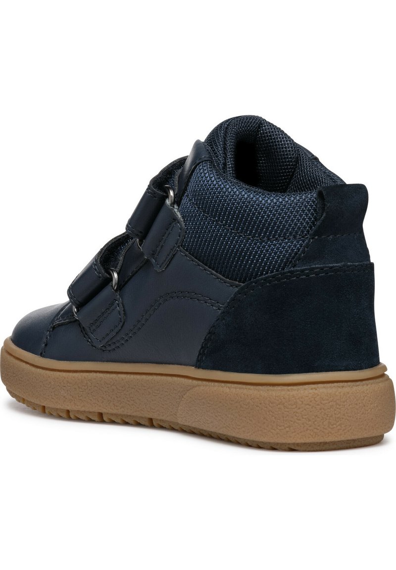 Des chaussures montantes bleu marine présentent une combinaison de cuir lisse et de maille texturée, un système de fermeture à double sangle et une semelle en caoutchouc durable.