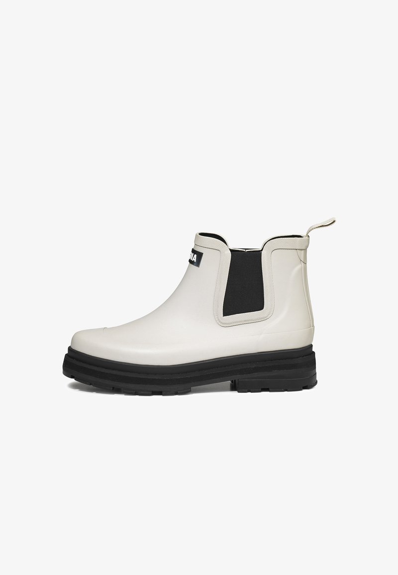 Bottes en caoutchouc blanches à chevilles avec un panneau élastique noir sur le côté, semelle noire contrastante et une languette à l'arrière pour un enfilage facile.