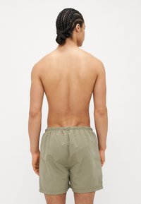 Férfi khaki fürdőshorts könnyű anyagból, rugalmas derékkal és laza, kényelmes fazonnal, minta nélkül.