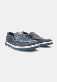 Pantofi slip-on din suede albastru cu talpă albă, având un accent din piele maro și detalii cusute pe partea superioară și pe laterale.