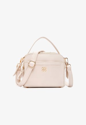 Kleine beige leren handtas met gouden beslag, een voorvak met rits, verstelbare schouderriem en handvat aan de bovenkant.