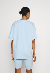 Camiseta de algodón de gran tamaño en azul claro, con mangas cortas y escote redondo, combinada con shorts de ciclismo en azul claro a juego.