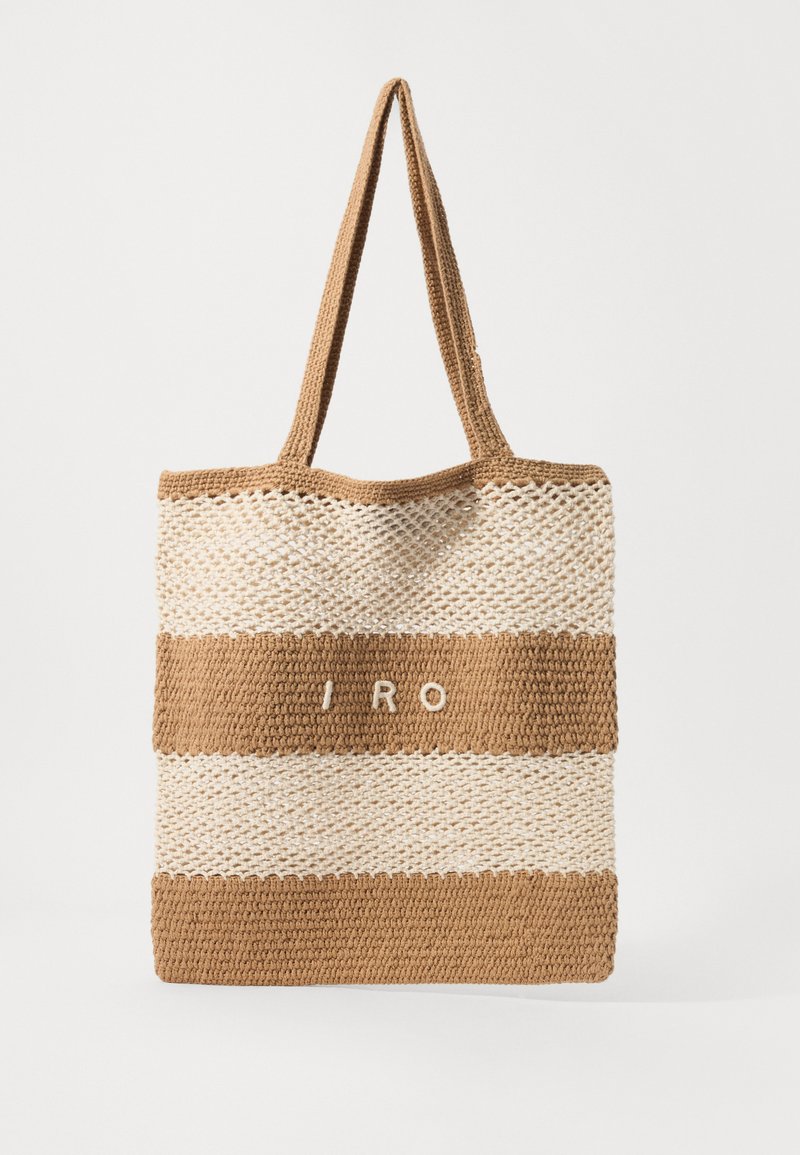 Sac fourre-tout tissé avec une texture de paille naturelle, présentant des rayures horizontales beiges et marron et l'inscription "I RO" en blanc. Deux poignées robustes.