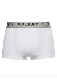 Boxers blancos con una cinturilla gris. La cinturilla presenta el texto "SUPERDRY" en negro. Hechos de una tela suave, similar al algodón.