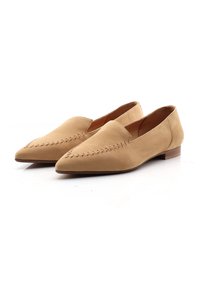 Beige suède instap schoenen met spitse neuzen, voorzien van decoratieve stiksels langs de bovenkant en een lage houten hak.