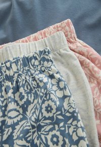 Trois paires de shorts légers : un à motif floral bleu, un gris clair et un à motif floral rose. Tailles élastiques avec coutures décoratives.