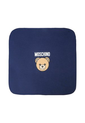 Donkerblauwe deken met een crèmekleurige beer gezicht graphic met de tekst "Moschino" erboven. Zachte textuur, ronde hoeken en een minimalistisch ontwerp.