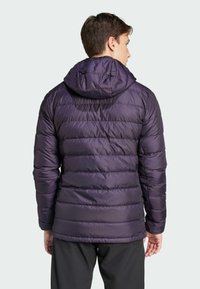 Lila Puffjacke mit horizontalem Steppmuster, Kapuze und elastischen Bündchen. Glatte Textur mit leichtem Aufbau.