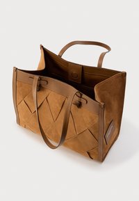 Καφέ δερμάτινη τσάντα ώμου με γεωμετρικό υφαντό σχέδιο, υφασμάτινη υφή, δύο λαβές και ένα κουμπί κλεισίματος. Το εσωτερικό είναι ευρύχωρο.