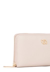 Portafoglio in pelle rosa chiaro con superficie testurizzata, zipper e accessori in tonalità dorata, e un logo geometrico minimale sul davanti.