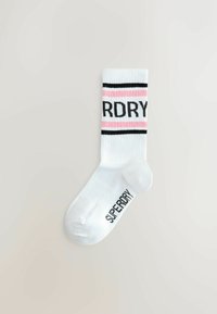 Valged sokid, millel on mustad ja roosad horisontaalsed triibud ning millel on must trükis 'SUPERDRY'. Pehme tekstuur ja crew-pikkuse disain.