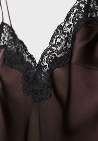 Vêtement en satin noir avec un décolleté en V profond bordé d'une dentelle florale noire délicate.