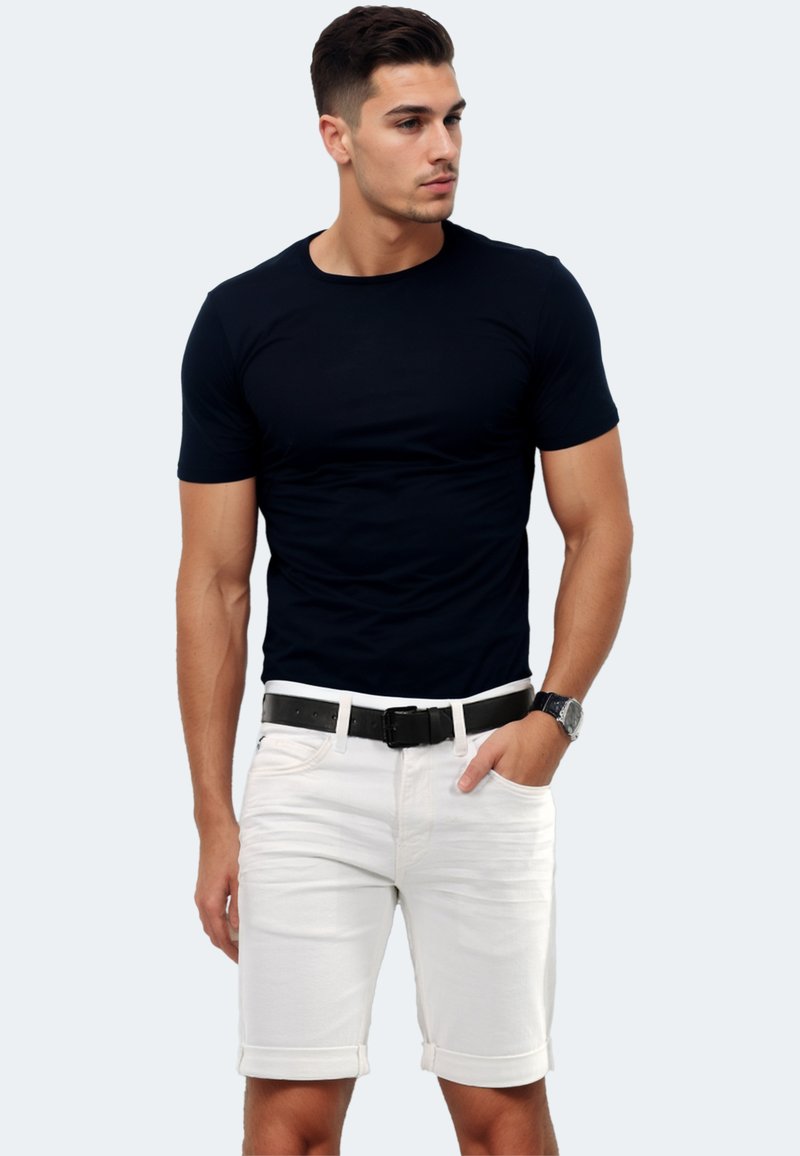 Black short-sleeve t-shirt paired with white denim shorts featuring rolled cuffs, a black belt, and a silver watch, displayed against a light background.