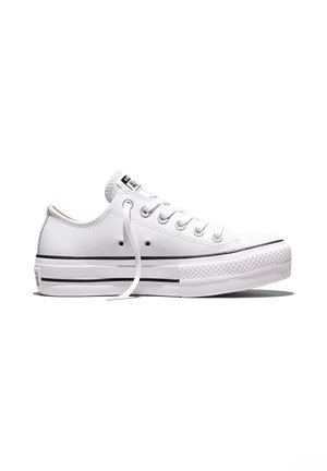 Biały niski sneaker z grubą podeszwą, czarnym paskiem, białymi sznurowadłami i otworami wentylacyjnymi po boku.
