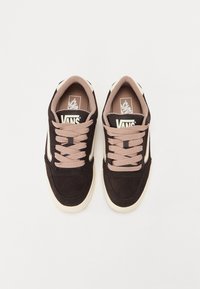 Baskets en daim marron avec des lacets roses, dotées d'une semelle en caoutchouc crème et d'accents latéraux. Logo Vans sur la languette et la semelle intérieure.