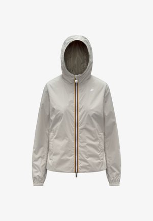 Giacca impermeabile color beige chiaro con cappuccio, cerniera frontale, polsini elastici, tasche laterali e piccolo logo sul petto a sinistra.