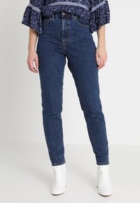 Džínové kalhoty s vysokým pasem v tmavě modré barvě se slim fit střihem, s texturovanou tkaninou a klasickým pětiokou designem.