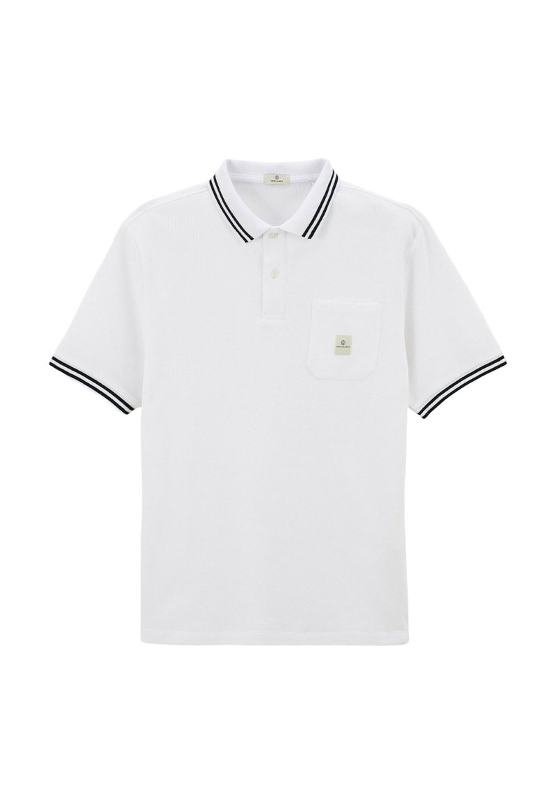 Polo blanc avec col et manches rayés noirs, arborant une petite poche sur la poitrine avec un écusson logo. Fabriqué en tissu texturé.