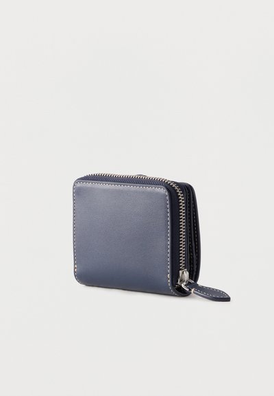 Συμπαγές πορτοφόλι από δέρμα σε navy μπλε χρώμα με λευκή ραφή και ασημί φερμουάρ με ταινία τράβηγμα σε ανοιχτό φόντο.