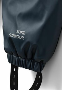 Bolsa negra de nailon con parte superior fruncida, que presenta el texto gris "SOFIE SCHNOOR". Incluye asas negras texturizadas con acentos de costura blanca.