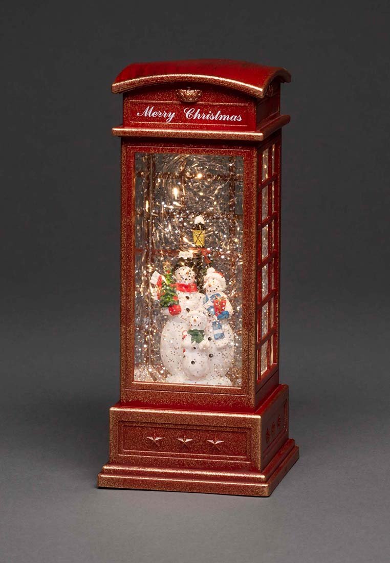 Rote Weihnachtslaterne mit dem Text "Frohe Weihnachten", die drei Schneemänner enthält, geschmückt mit Schals, Geschenken und einer Laterne im Inneren.