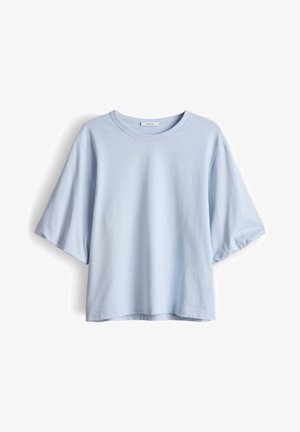 T-shirt azzurro chiaro in cotone, a maniche corte e vestibilità ampia, con scollo rotondo e una piccola etichetta del marchio all'interno del colletto.