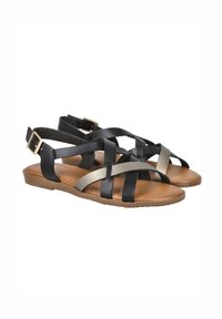 Sandalias de cuero negras y doradas metálicas con amplias correas cruzadas, una suela plana y una correa en el tobillo con hebilla. Textura suave y diseño casual.