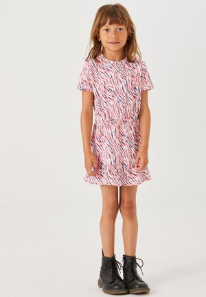 Korte mouw jurk in roze en witte zebra print met een verzamelde taille en een rimpelrand, gecombineerd met zwarte veterschoenen.