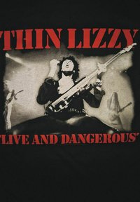 Musiikki esittää kitaraa jalat levällään lavalla, bändin jäseniä ja spotlightteja taustalla, punainen "Thin Lizzy Live and Dangerous" -teksti.