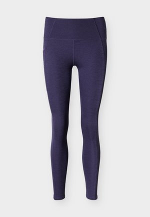 Leggings texturés taille haute de couleur violet foncé avec un design sans coutures et des jambes ajustées longueur cheville sur fond blanc.