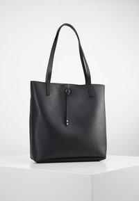 Czarna torba typu tote wykonana z teksturowanego syntetycznego materiału, z dwoma uchwytami na ramię oraz ozdobnym skórzanym trokiem z metalowymi detalami.