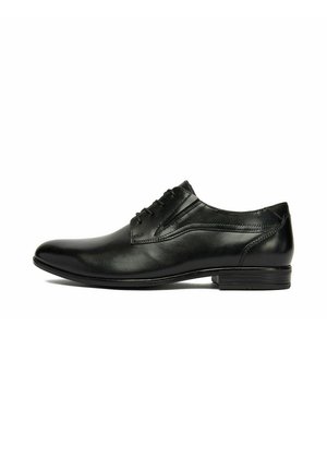 Zapato formal de hombre de piel negra con cordones, tacón bajo y acabado liso y elegante, mostrado de lado sobre un fondo blanco.