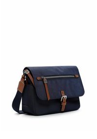 Sac bandoulière bleu marine avec sangle en cuir marron, poche zippée sur le rabat et fermeture à boucle à l'avant, présenté sur fond blanc.