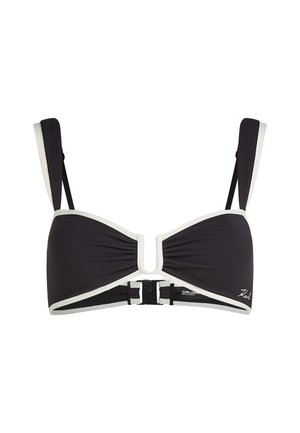 Top bikini nero con rifiniture bianche, caratterizzato da un dettaglio centrale a forma di U e spalline regolabili. Tessuto strutturato con chiusura a fibbia sicura.