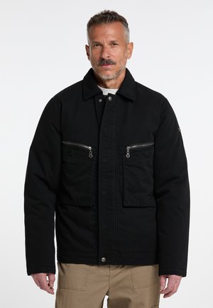 Schwarze Baumwolljacke mit Kragen, zwei Reißverschlusstaschen auf der Brust und Knopfverschluss. Besitzt eine glatte Textur und ein entspanntes Passformdesign.