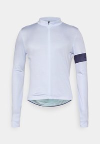 Jasnoniebieska, długorękawowa koszulka rowerowa z wysokim kołnierzykiem, pełnym zamkiem błyskawicznym i granatowym akcentem na lewym rękawie. Wykonana z gładkiego, lekkiego materiału.
