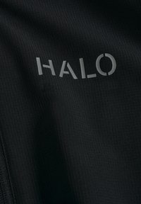 Czarna tkanina o prążkowanej strukturze ma słowo "HALO" w jasnoszarym, lekko błyszczącym wykończeniu.
