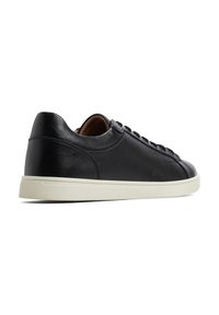 Svart lädersneaker med en slät yta, med vit gummisula, rund tå och snörningsdesign. Minimalistisk och modern stil.